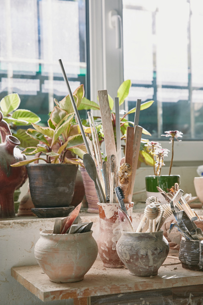 foyer sélectif des outils de poterie et pinceaux à table en atelier de poterie
 - Photo, image
