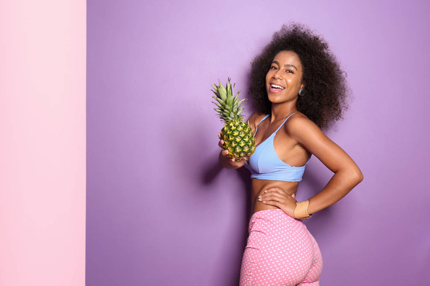 Mulher afro-americana bonita com abacaxi sobre fundo de cor - Foto, Imagem