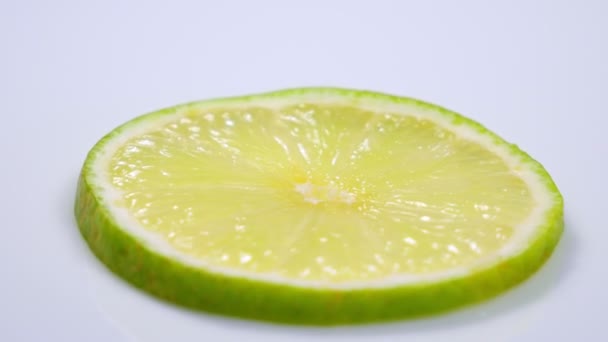 Свіжий зелений шматочок лимона повільно обертається в студії з деталями
. - Кадри, відео