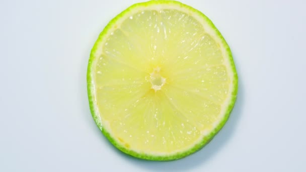 rodaja de limón verde fresco está girando lentamente en el estudio con los detalles
. - Metraje, vídeo