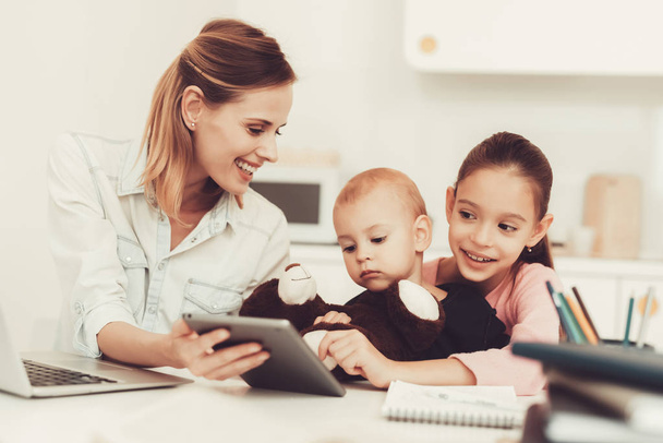 Mom And Daughter Are Playing With Little Baby. Family Relationship Concept. Gadget Screen. Taping On Keyboard. Little Hands. Active Family. Holiday Leisure. Happy Childhood. Parent's Duty. - 写真・画像