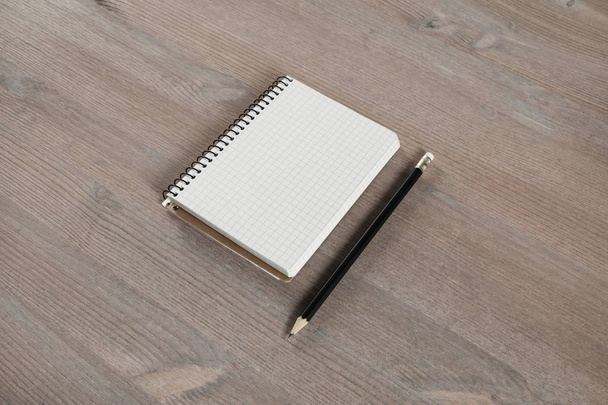 Blank notebook and pencil on wood table background. - Photo, Image