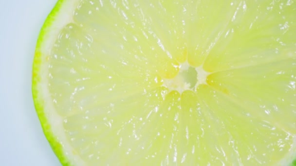 Φρέσκο πράσινο λεμόνι φέτα περιστρέφεται αργά στο στούντιο με τις λεπτομέρειες. - Πλάνα, βίντεο