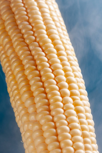 Corn boiled sweet, steam around the cob on a heavenly background, a good concept for a restaurant. - Foto, Imagen