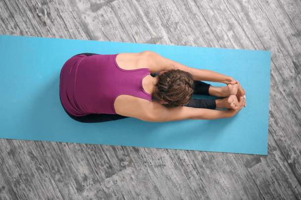 Sporty woman practicing yoga indoors - Photo, Image