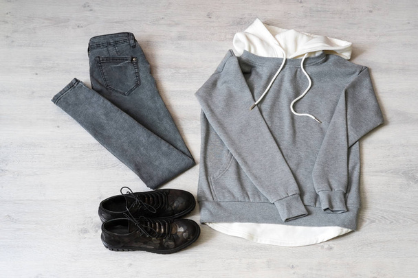 Tiener kleding set: grijze sweater, zwarte jeans en laarzen in militaire stijl - Foto, afbeelding