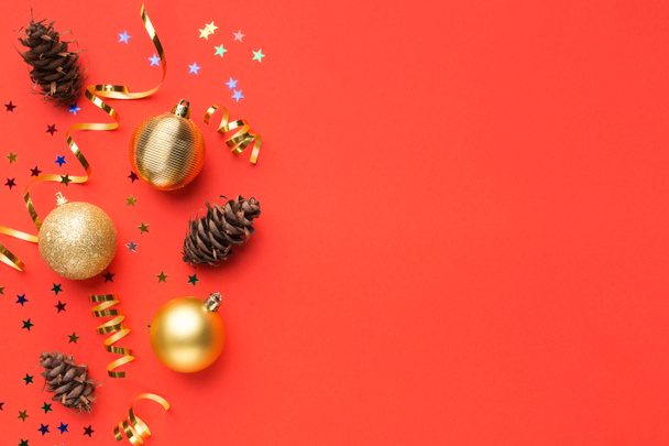 Christmas balls and pine cones on red background - Photo, Image