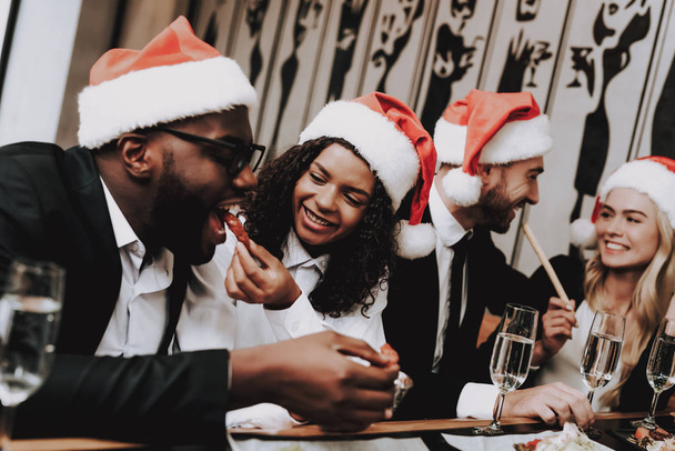 Santa's Hat. Have Fun. Young People. Rest. Girls and Guys. Drink Alcoholic Beverages. Different Races Communicate. Bar. Together. Clubbing. Nightlife. Joyful. Chin-chin. Leisure. Positive. Emotion. - Fotoğraf, Görsel