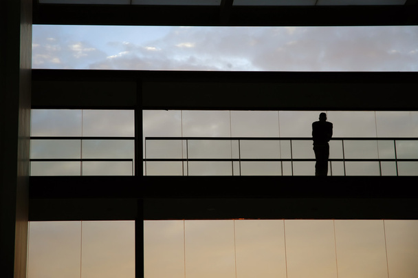 Trabajador dentro de la silueta del edificio al atardecer
 - Foto, Imagen