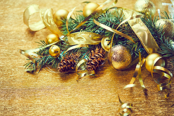 Ramo de árvore de Natal com bolas douradas e fitas com cones de pinho
 - Foto, Imagem