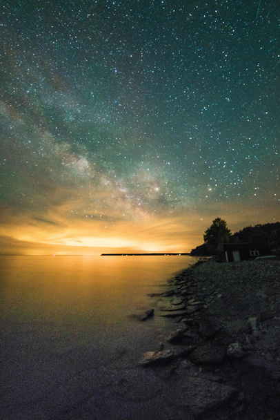 Via lattea e stelle sopra l'acqua di notte
 - Foto, immagini