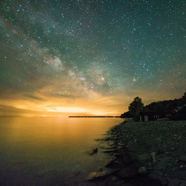 Vía Láctea y estrellas sobre el agua por la noche
 - Foto, imagen