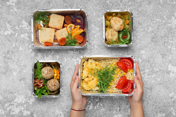 Фольга контейнеры с вкусной едой на сером фоне
 - Фото, изображение
