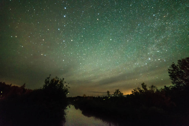 Csillagok és az éjszakai égbolt, mint egy tó, a szentjánosbogarak - Fotó, kép