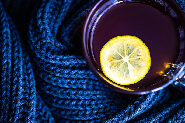 Kopje thee met citroen en warme gebreide sjaal als winter concept - Foto, afbeelding