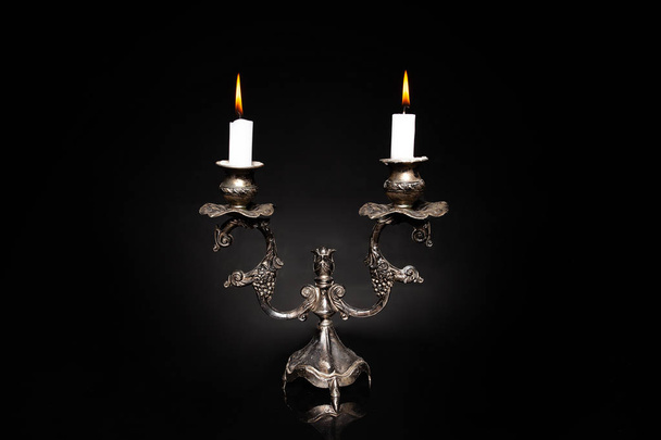 подсвечник, винтажный серебряный подсвечник с горящей свечой
 - Фото, изображение
