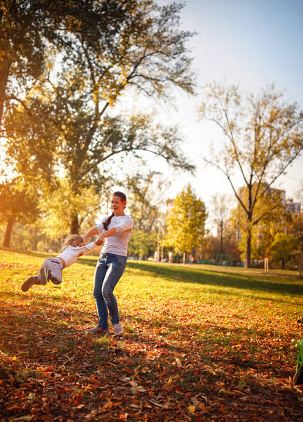 Lustiger Tag - Mutter verbringt Zeit mit ihrem kleinen Sohn im Herbstpark - Foto, Bild