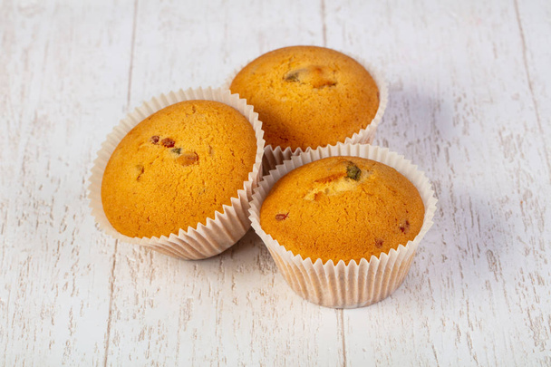 Sweet tasty muffins over wooden background - Photo, Image