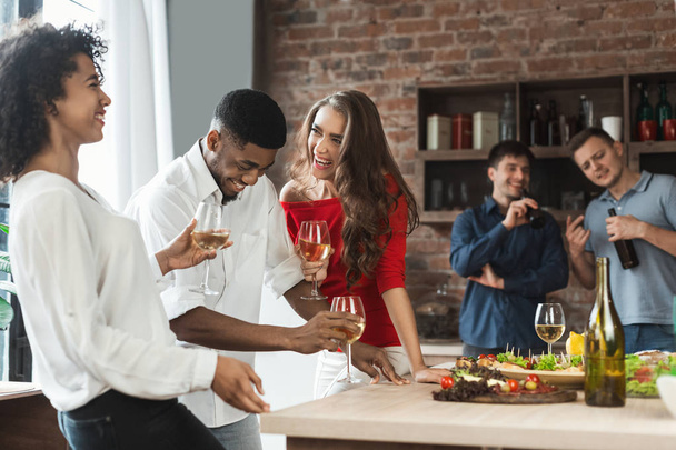 Nadšený přátelé pití a smáli se v kuchyni - Fotografie, Obrázek