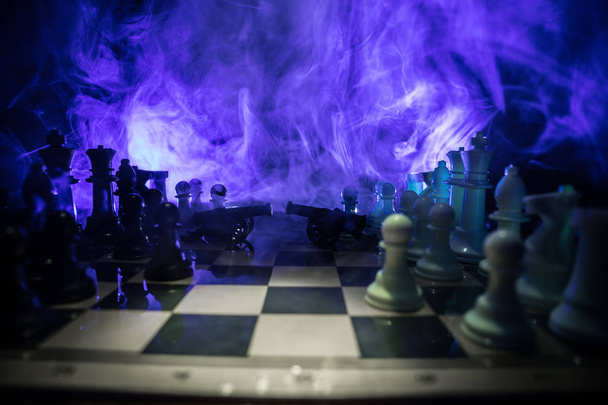Средневековая боевая сцена с двумя пушками на шахматной доске. Шахматные настольные игры концепции бизнес-идей и конкуренции и стратегических идей Шахматные фигуры на темном фоне с дымом и туманом
. - Фото, изображение