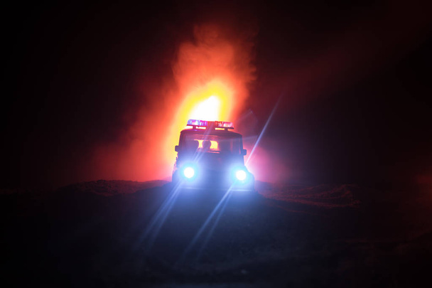 Voiture de police pourchassant une voiture la nuit avec un fond de brouillard. 911 Intervention d'urgence voiture de police accélérant sur les lieux du crime. Concentration sélective - Photo, image