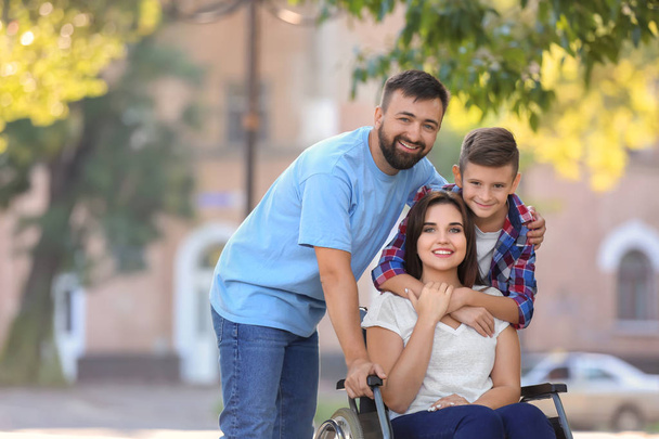 Açık havada yürüyüş ailesiyle birlikte tekerlekli sandalyede genç kadın - Fotoğraf, Görsel