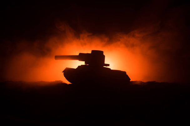 Háború fogalmát. Páncélozott tartály sziluettjét alatt ködös tűz ég éjszaka. Támadás jelenet. Dekoráció játék. Szelektív összpontosít - Fotó, kép