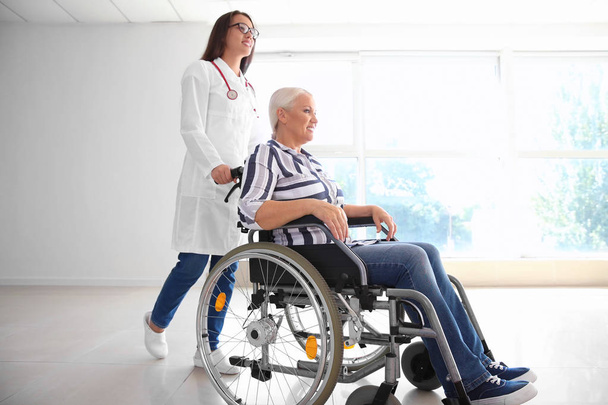 Femme mature handicapée avec jeune femme médecin à la clinique
 - Photo, image