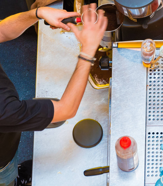 Unrecognisable barista making coffee at coffee machine in shop. Top aerial view - Photo, image