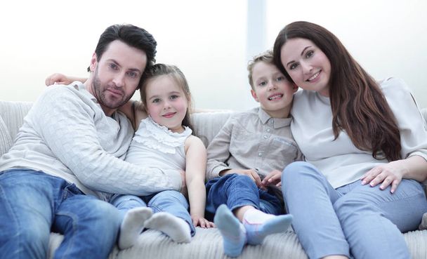 parents hug their children sitting on the couch - Photo, Image