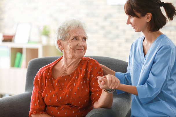 Enfermera joven visitando a anciana en casa
 - Foto, Imagen