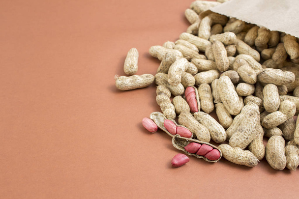 Amendoins abertos saindo do saco de pape - Φωτογραφία, εικόνα