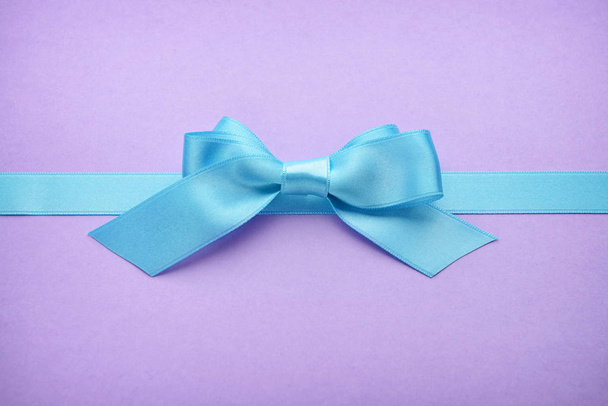 Blue ribbon with bow on color background - Photo, Image