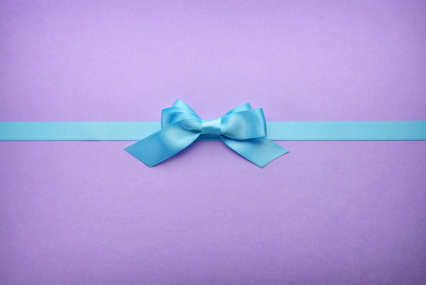 Blue ribbon with bow on color background - Foto, imagen