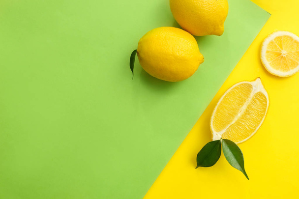 Composición laica plana con limones jugosos maduros sobre fondo de color
 - Foto, imagen
