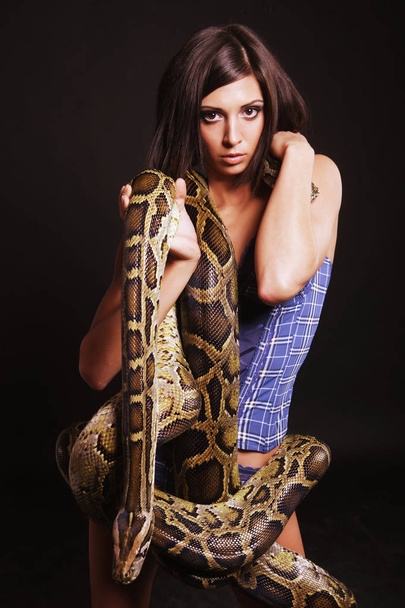 sexy brunette holding python - Foto, afbeelding