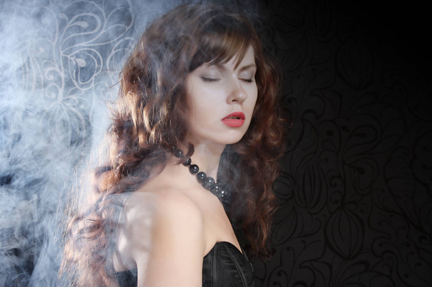 young and sexy woman in smoke  - 写真・画像