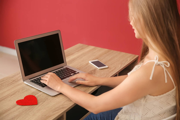 Genç kadın kapalı flört sahip dizüstü bilgisayar ile - Fotoğraf, Görsel