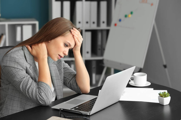 Woman suffering from headache and neck pain in office - Zdjęcie, obraz