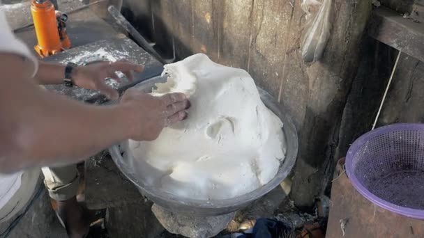 Gros plan sur l'homme remplissant la machine de pressage de nouilles avec de la pâte de riz
 - Séquence, vidéo