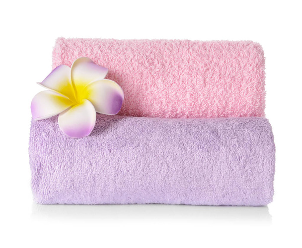 Rolou toalhas macias limpas com flor no fundo branco
 - Foto, Imagem