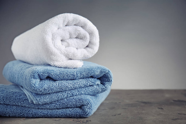 Clean soft towels on table against grey background - Photo, Image