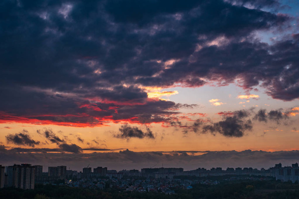 Dramatic colorful autumn clouds at sky over city at sunset, beautiful nature landscape panorama - Photo, Image