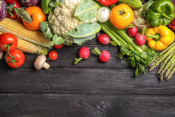 Flat lay composition with assortment of fresh vegetables on wooden table. Space for text - Photo, Image