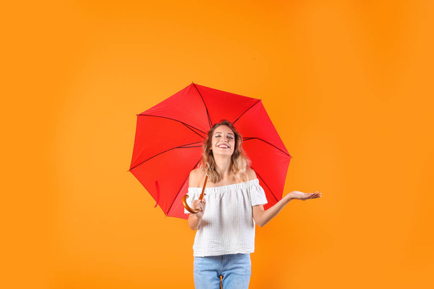 Woman with red umbrella on color background - Photo, image
