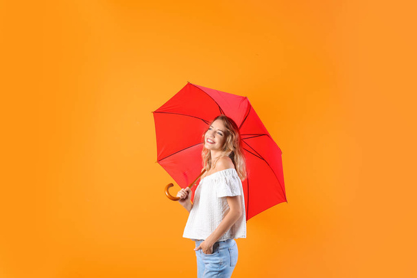 Woman with red umbrella on color background - Foto, immagini