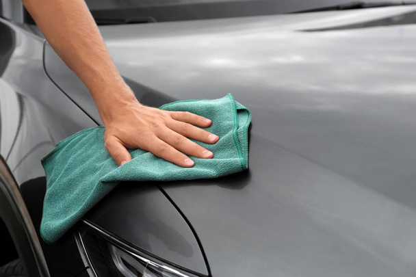 Man washing car hood with rag, closeup - Foto, imagen