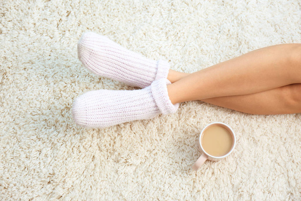Woman and cup of coffee on carpet, closeup. Floor heating - Фото, зображення
