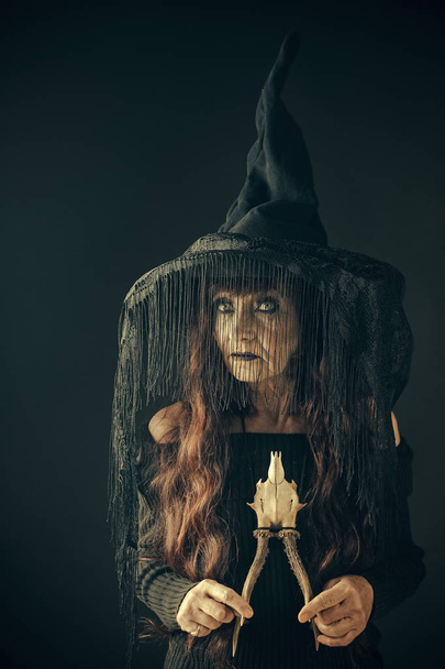 Halloween woman in black with long red hair and makeup. - Zdjęcie, obraz