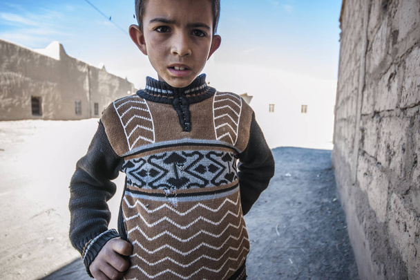 Portrait of a boy looking up at the camera in village Merzouga, Morocco - Photo, Image